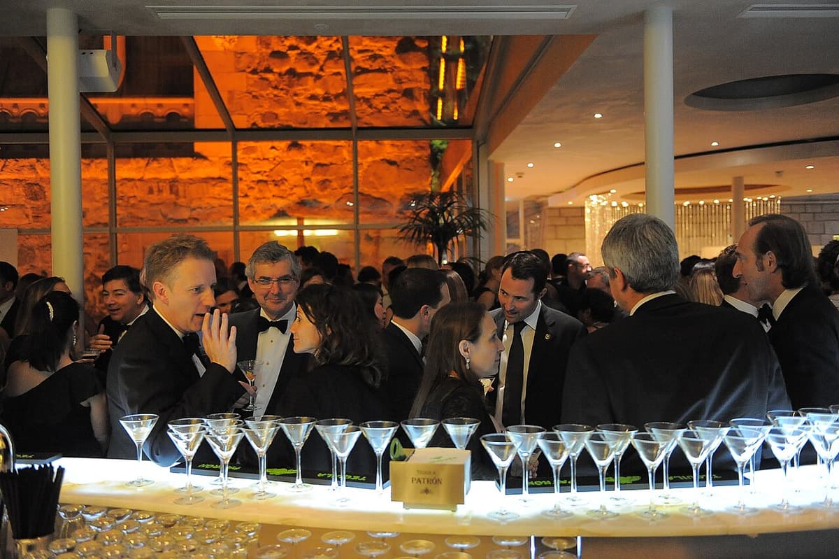 A crowded cocktail bar full of overlapping conversations — the cocktail party effect from attention psychology that led Colin Cherry to name the shadowing technique